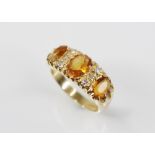 A citrine and diamond 18ct gold ring, designed as three oval mixed cut citrines measuring between