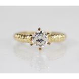 A diamond solitaire ring, the central round brilliant cut diamond weighing approximately 0.70