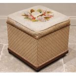 A Victorian mahogany framed ottoman, of cubic form, the hinged upholstered needlework top opening to