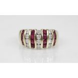 A ruby and diamond 9ct gold bombe ring, the head designed as alternating rows of brilliant cut