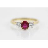 A ruby and diamond three stone ring, the central oval mixed cut ruby (untested) measuring 5.6mm L