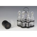 A six bottle cruet set, each clear glass double lipped bottle with associated stopper, and