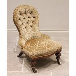 A Victorian walnut and upholstered nursing chair, in foliate damask fabric, the button back above