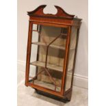 An Edwardian Sheraton revival wall hanging mahogany display cabinet, the broken architectural