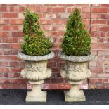 A pair of reconstituted stone garden urns, of campana form, the fluted bodies applied with human