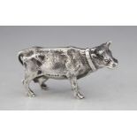 A silver figure of a cow, marks for 'SMD' London 1969, modelled standing wearing a collar with fur
