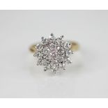 A diamond floral cluster ring, designed as a tiered cluster of nineteen round brilliant cut