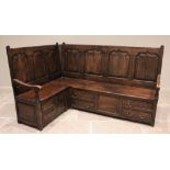 A George III style oak corner settle, late 20th century, the 'L' shaped settle with seven fielded