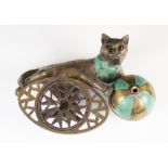A novelty brass wool winder, modelled as a cat chasing a ball, incised to reverse 'From the Model by