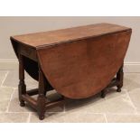 An 18th century oak drop leaf table, the oval top above a single frieze drawer, raised upon ring