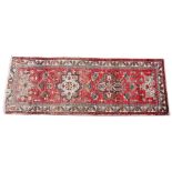 An Iranian red ground floor runner, with stylized floral gulls enclosed within a geometric border,