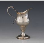 A George III silver cream jug, London 1786 (maker's marks worn), the baluster from body with