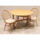 An Ercol blonde elm drop leaf breakfast table, late 20th century, the oval top raised upon trestle