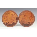 A pair of Intarsia wood circular marquetry plaques, early 20th century, each possibly depicting