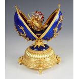 A Limited Edition musical 'Faberge Firebird Egg' by Franklin Mint, the silver gilt egg with blue