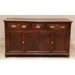 A George II oak dresser base, the rectangular moulded plank top above an arrangement of three lip-