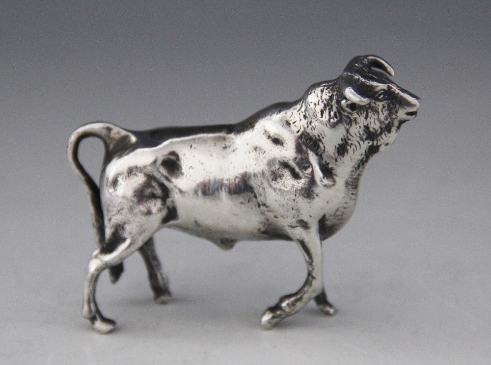 A silver coloured figure of a bull, realistically modelled with fur effect chasing, 7.5cm long