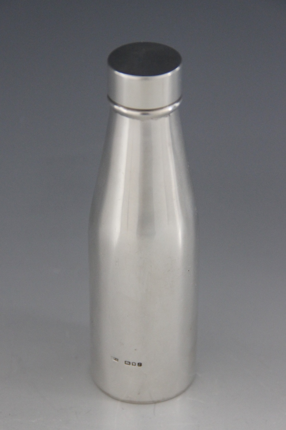 A novelty silver bottle, marks for 'PTM' London 1973, of tapering plain polished cylindrical form
