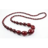 An amber bead necklace, comprising seventy-three graduated polished oval cherry amber beads,