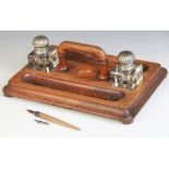 An early 20th oak desk tidy, of rectangular form with a pair of inset cubic glass inkwells each