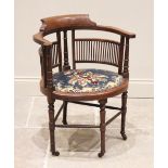 An Edwardian mahogany corner chair, the curved arm rail raised upon three ring turned and ring