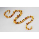 A string of amber beads, comprising forty-seven graduated spherical beads measuring between 6.22mm