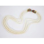 A cultured pearl necklace with 18ct ruby and turquoise set clasp, comprising three rows of round