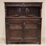An 18th century carved oak cwpwrdd deuddarn/court cupboard, the upper frieze carved with scrolling