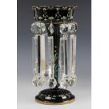 A Victorian black glass Lustre, of trumpet form suspending ten assorted glass drops beneath an