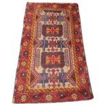 An Afghan Baluchi rug, in red, blue and orange colourways, the geometric design with two rectangular