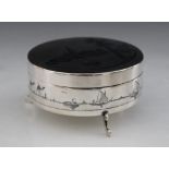 An Iraqi niello type white metal jewellery box, the circular box and cover, decorated with river
