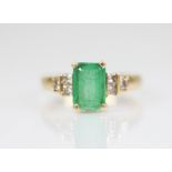 An emerald and diamond 18ct gold ring, the central rectangular step cut emerald measuring 8.60mm x