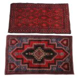 A Caucasian wool rug, in red and blue colourways, with central graduated geometric medallions,