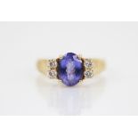 A tanzanite and diamond 18ct gold ring, the central mixed cut oval tanzanite measuring 9mm x 6.