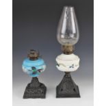 A Victorian blue opaline glass oil lamp, over painted with floral detail and raised upon a pierced