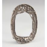 An Arts and Crafts silver coloured frame, of oval form and designed as an owl perched in trees,