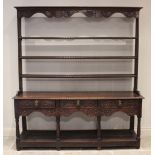 A George III and later carved oak pot board dresser, the high back with a moulded cornice over a