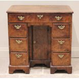 A George I figured walnut ladies kneehole desk, the quarter veneered top with feathered banding