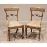 A pair of painted Regency side chairs, each with a concave top rail centred with a painted