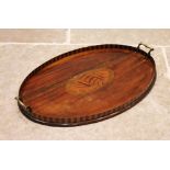 A George III mahogany and marquetry inlaid tray, the oval tray with a banded and chequered gallery