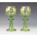 A pair of Bohemian green glass Historismus goblets of large proportions, the bowls hand-decorated