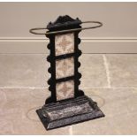 A Victorian cast iron tile back stick stand, the curved brass guard above three inset tiles and a