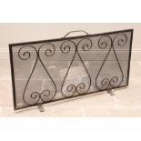An iron spark guard, 20th century, of rectangular form, constructed with wrought iron scroll
