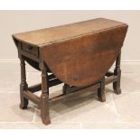 An 18th century oak drop-leaf table, the hinged oval top above a pair of opposing frieze drawers,