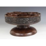 An African hardwood carved lazy susan, of circular form, the border carved with labouring figures,