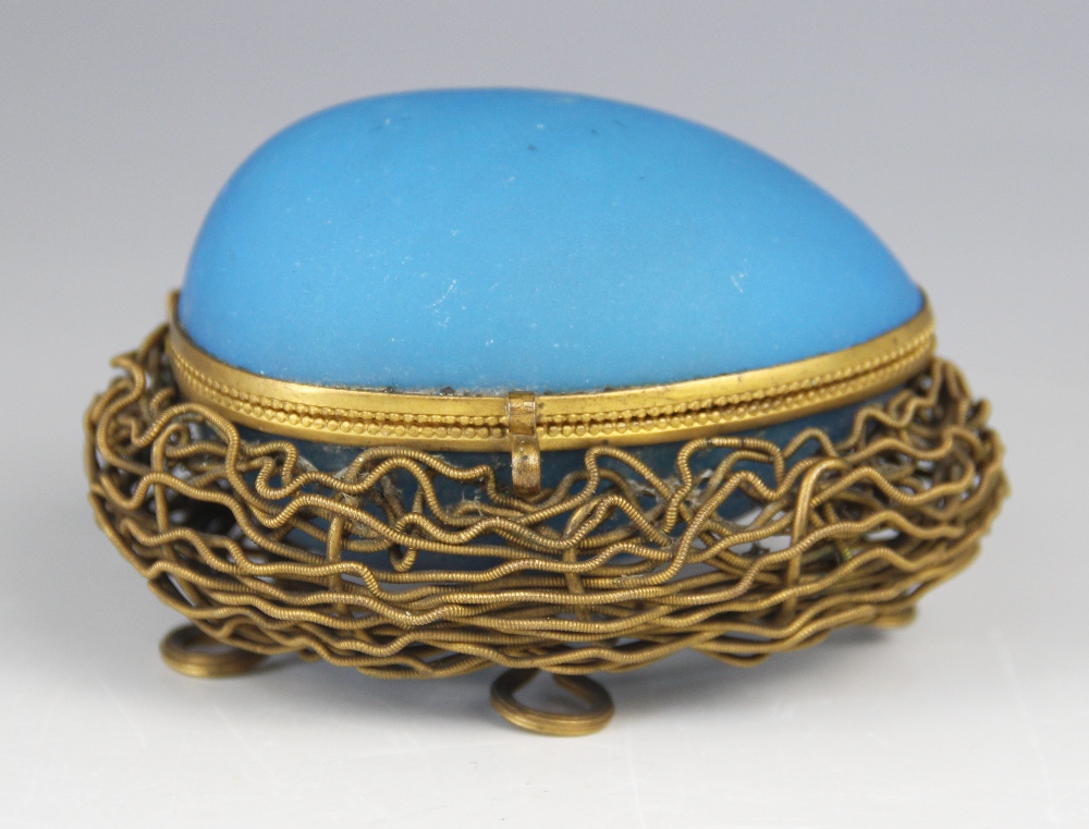 A mid-19th century French etui, modelled as a blue glass egg upon a gilt metal nest raised on four