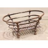 A cast iron fire basket, constructed from three graduated oval rails, upon four supports each with