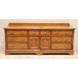 A George III honey oak and mahogany cross banded dresser base, the rectangular top with a moulded