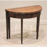 A George III mahogany demi lune tea table, the folding top with a channelled edge above a figured