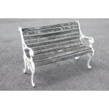 A 19th century style painted metal and slatted hardwood bench, the supports cast with lion mask